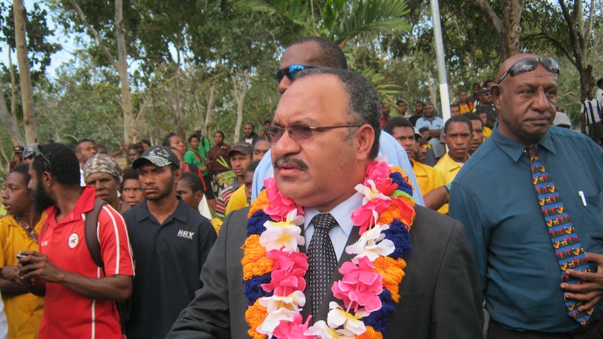 Papua New Guinea's Prime Minister Peter O'Neill with a wreath of flowers.