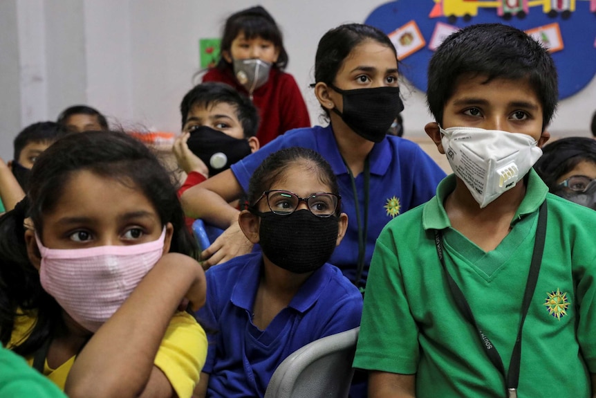 Jeunes enfants en Inde portant des masques faciaux dans une salle de classe