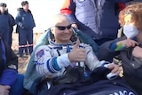 US astronaut gives thumbs up after landing back on earth.