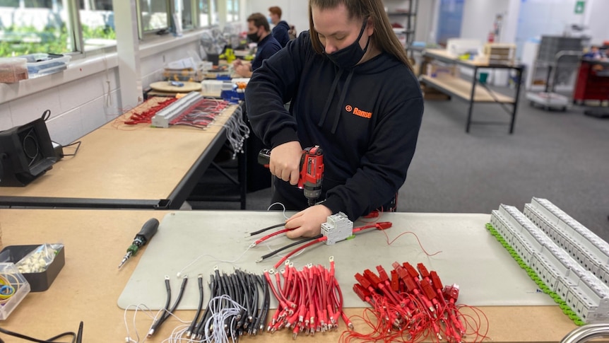 a woman with electrical tools in a factory