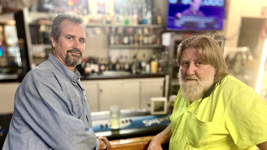 Two men, one wearing high vis, sit at the bar of a pub in the Hunter Valley, January 2021.