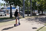 Man rides e-scooter down Townsville street