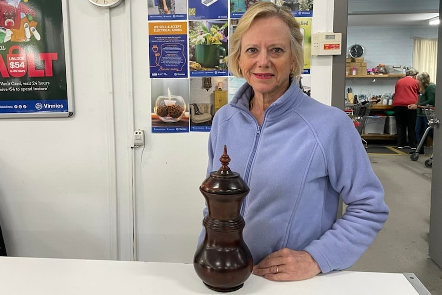 woman smiling standing at desk with urn