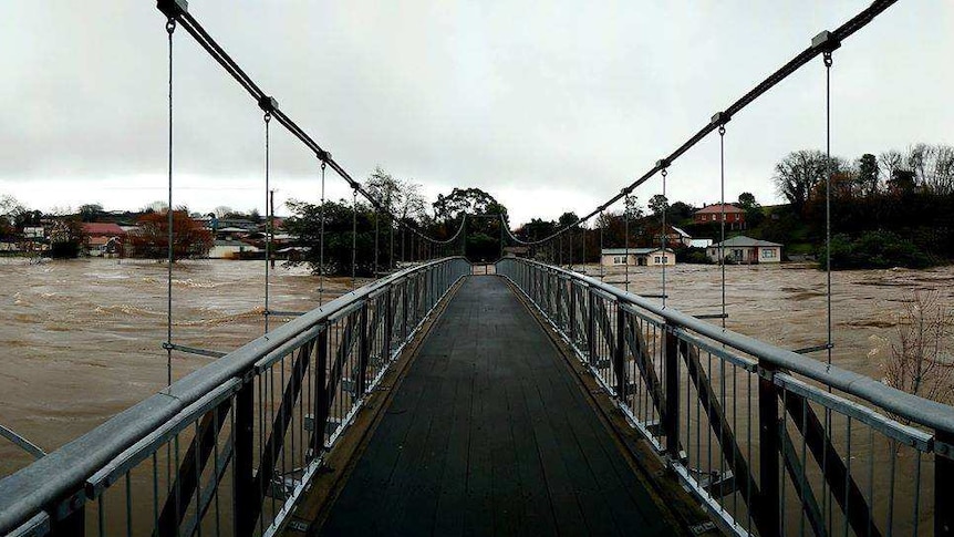 Flooding waters creep higher towards a train park bridge in Deloraine, Tasmania.
