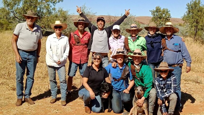 Group of people stand posing for a photo in outback Australia.