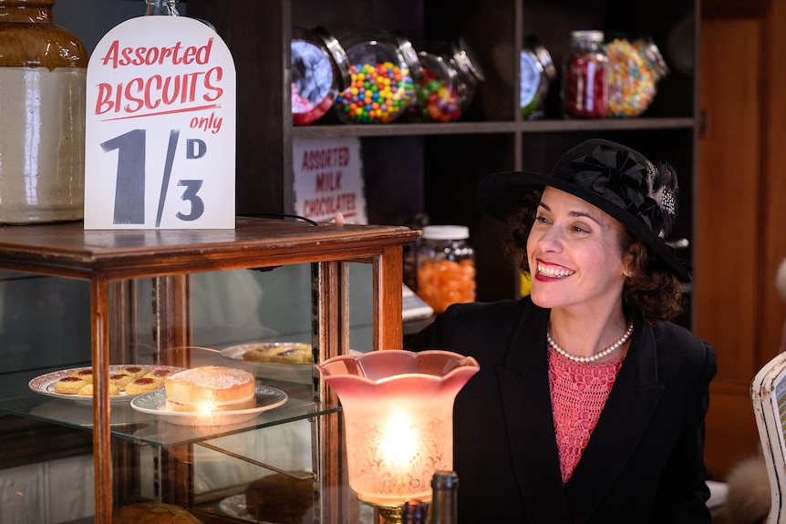 Woman in period dress in an old fashioned shop.