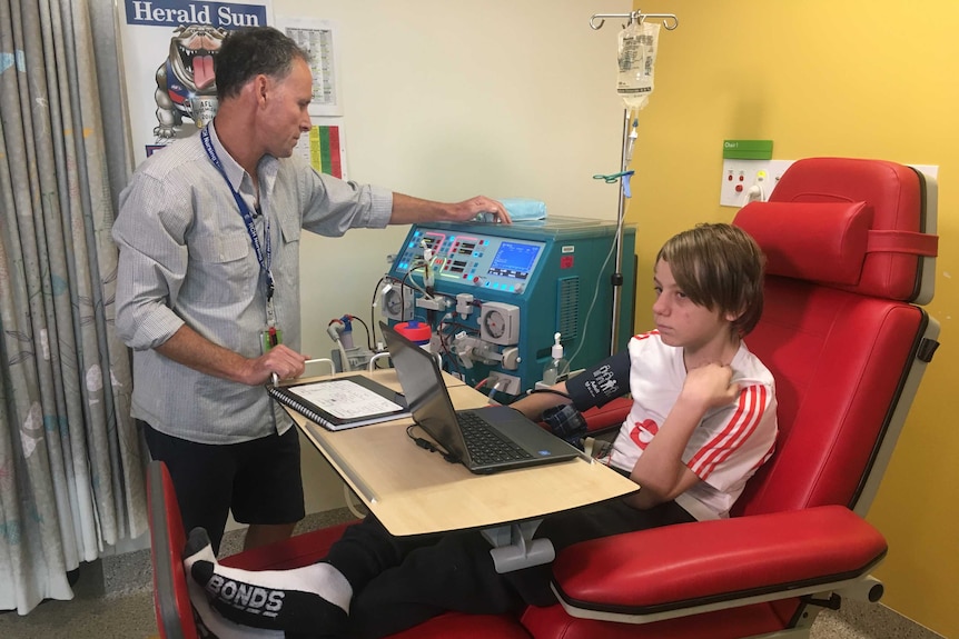 Ryan Lambley sits in hospital connected to a dialysis machine.