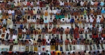 An image taken from above shows Indonesians praying in the style of the Muslim faith.