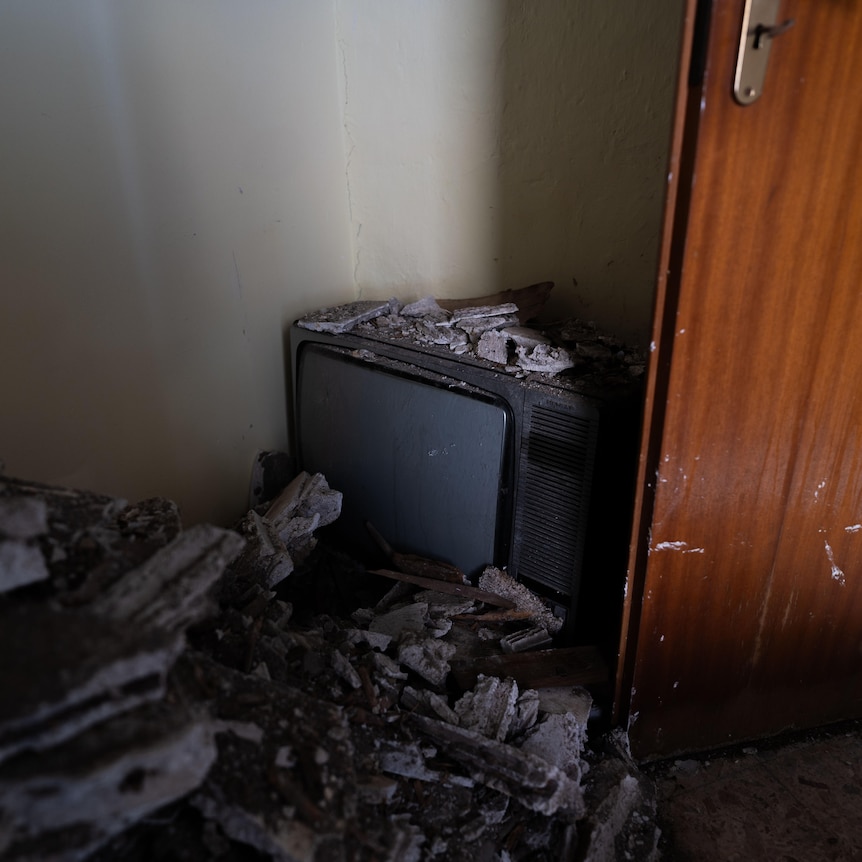 A TV covered in rubble.