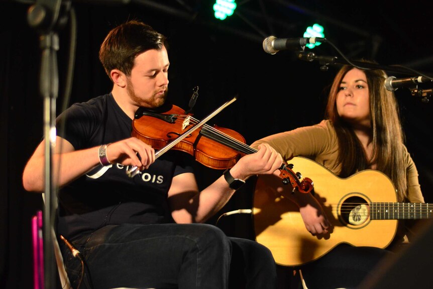 Robbie Mackenzie and Kaitlin Ross from Fèis Rois play a fiddle and guitar.