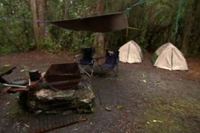 A campground with two tents and two chairs