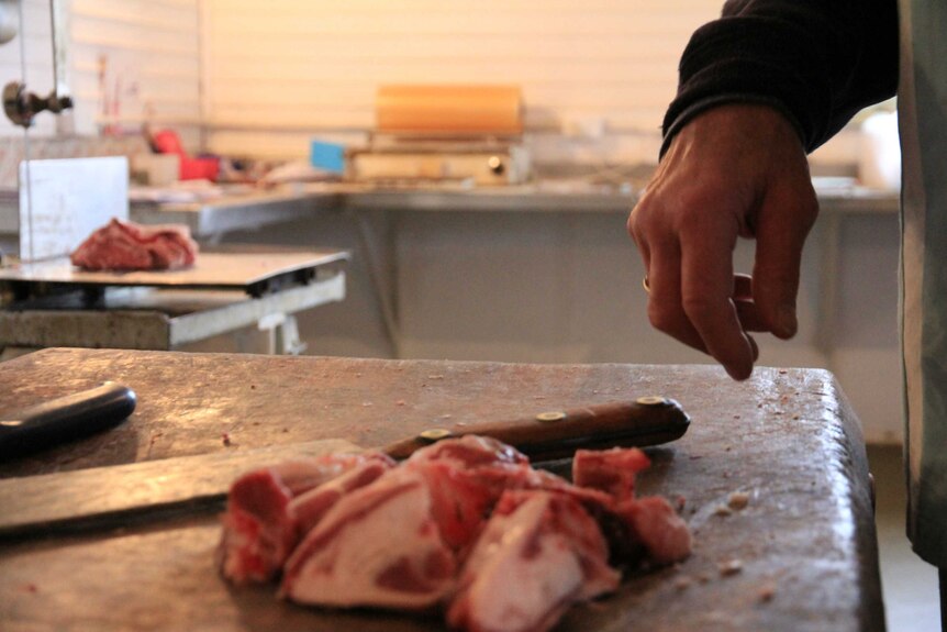 Paul Bennett cutting up the last bits of meat at his butcher.
