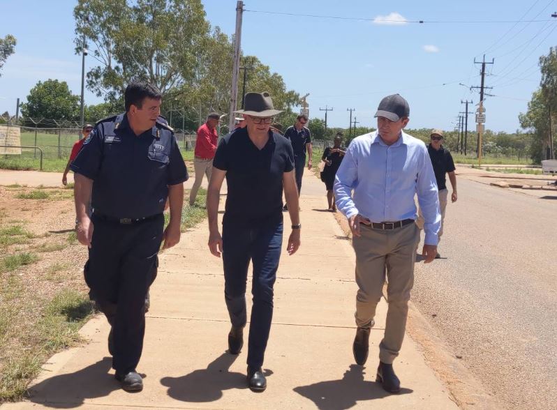 Anthony Albanese and Mark McGowan walk along a road in a rural community