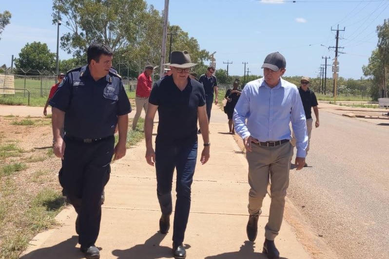 Anthony Albanese and Mark McGowan walk along a road in a rural community