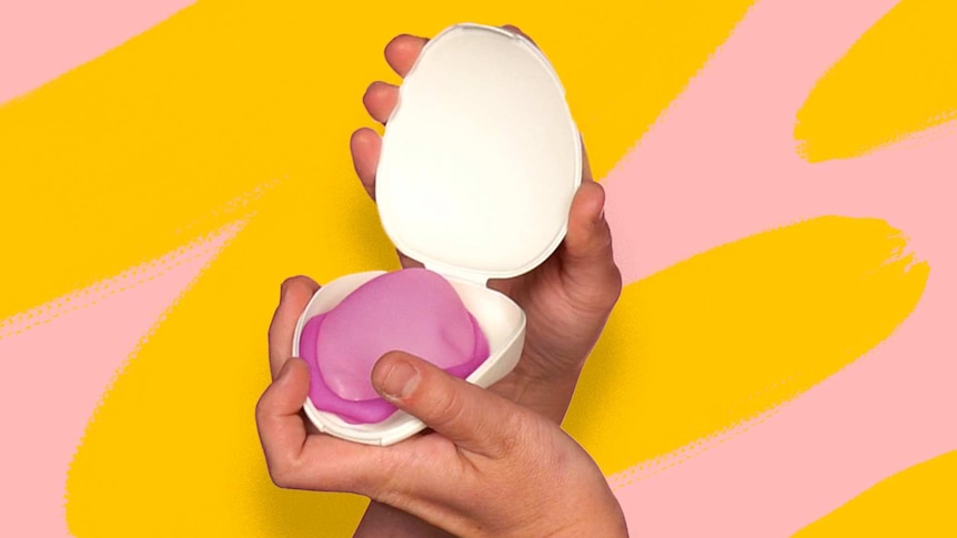 A woman's hands holding an open white case housing a purple diaphragm for a story about how diaphragms work.