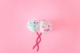 Two heart balloons sit on a pink background to depict settling for an average connection in a romantic relationship.