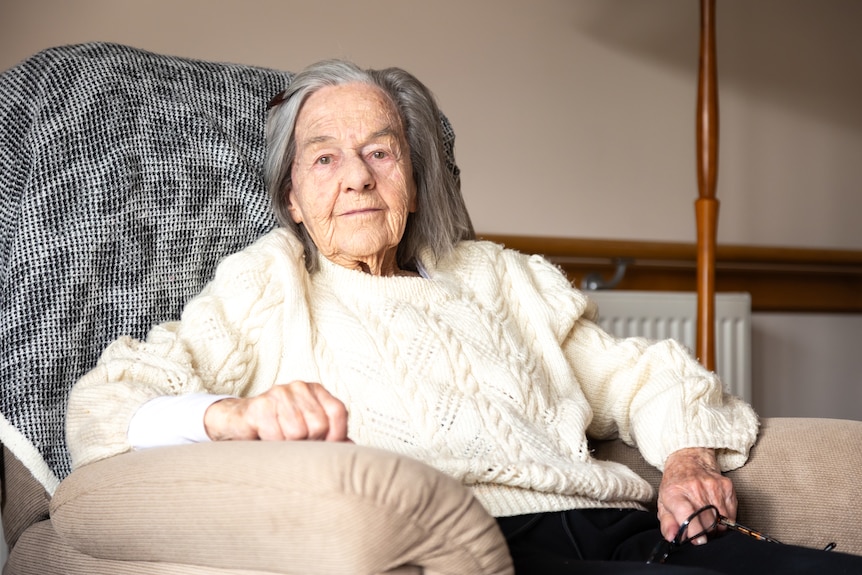 An elderly lady sitting in an armchair. 