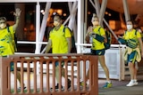 Four Olympic athletes wave to the cameras as they arrive at Darwin Airport.
