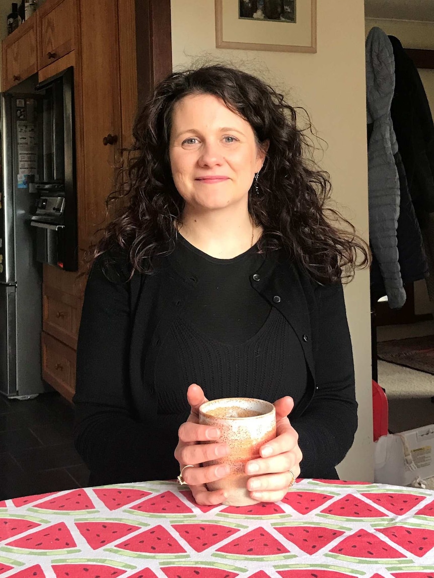 Kate Ravenscroft holding a cup of tea at a kitchen table