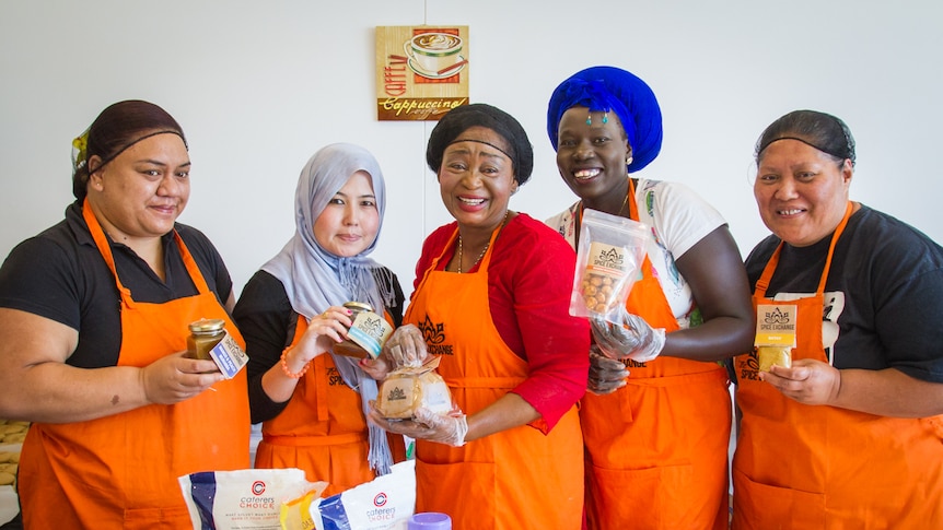 Women holding chutneys, gingerbread and spices.