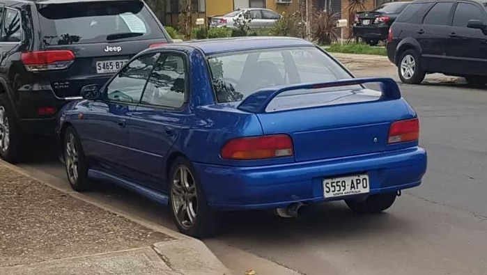 A blue sedan in a suburban street