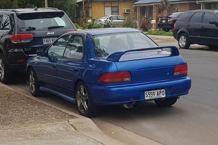 A blue sedan in a suburban street