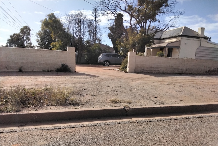 A dirt footpath outside a house in Broken Hill, with no access for a wheelchair.