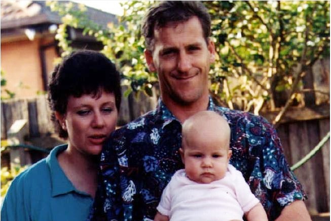An old photo shows Craig Folbigg, holding a baby, standing next to Kathleen Folbigg.