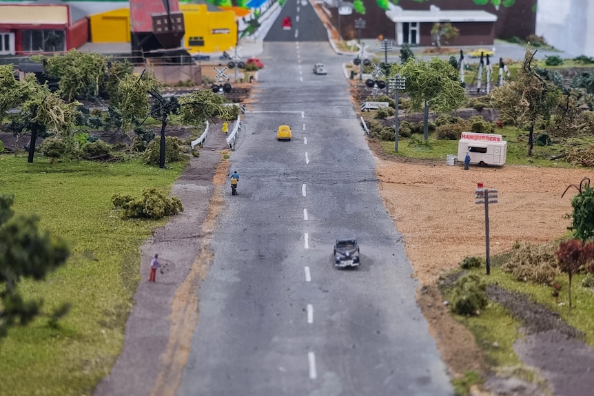 A replica country road, with a hamburger stand in a dirt patch on the die