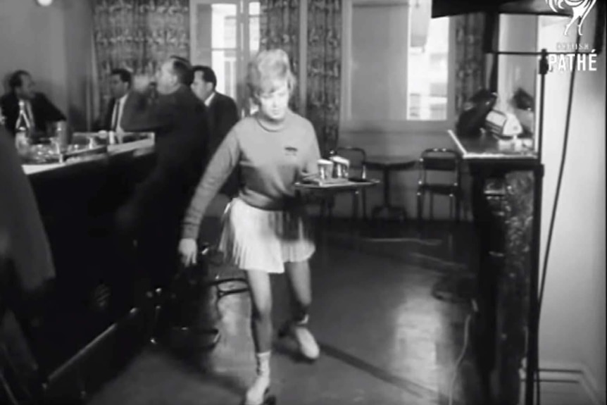 Brigitta Suba skating with a tray of drinks in 1962.