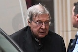 George Pell is escorted by prison guards from a van outside the Supreme Court building.