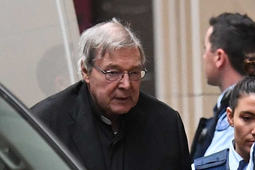 George Pell is escorted by prison guards from a van outside the Supreme Court building.
