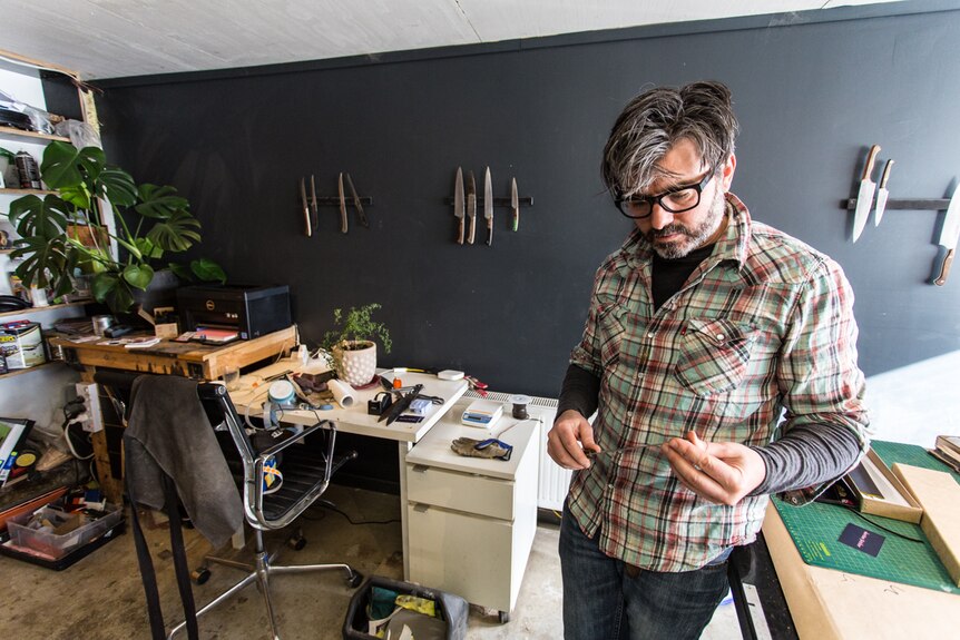 Todd Neale in his Castlemaine workshop looking down at his knife.