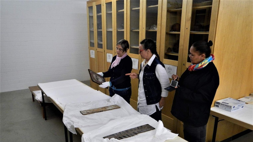 Three women look at an old painting