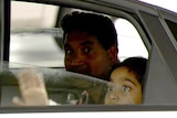 A man and child in the back of a car.