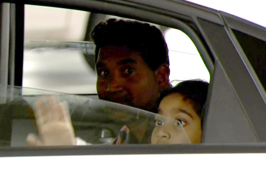 A man and child in the back of a car.