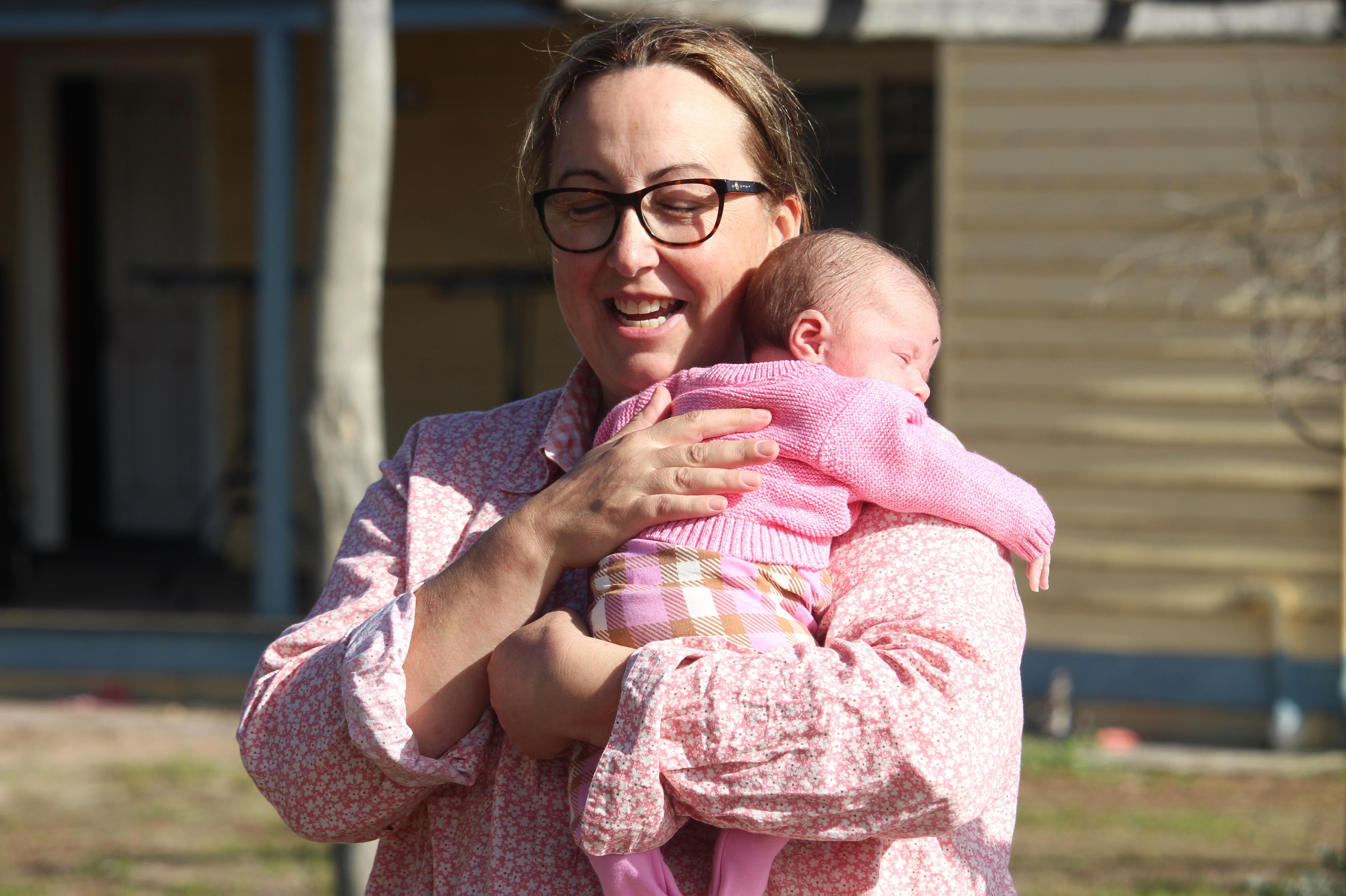 A woman hugs her baby. 