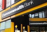 Outside of a branch of the Commonwealth Bank with signage and two atm machines