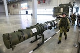 A Russian military officer walks past the 9M729 land-based cruise missile on display with its launcher