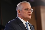 Scott Morrison stands before a podium speaking.