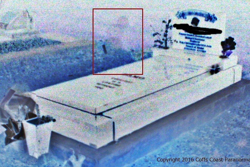 A photo of a grave with a blurry shape believed to be a spirit