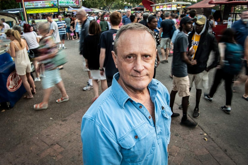 A man stands among a crowd.