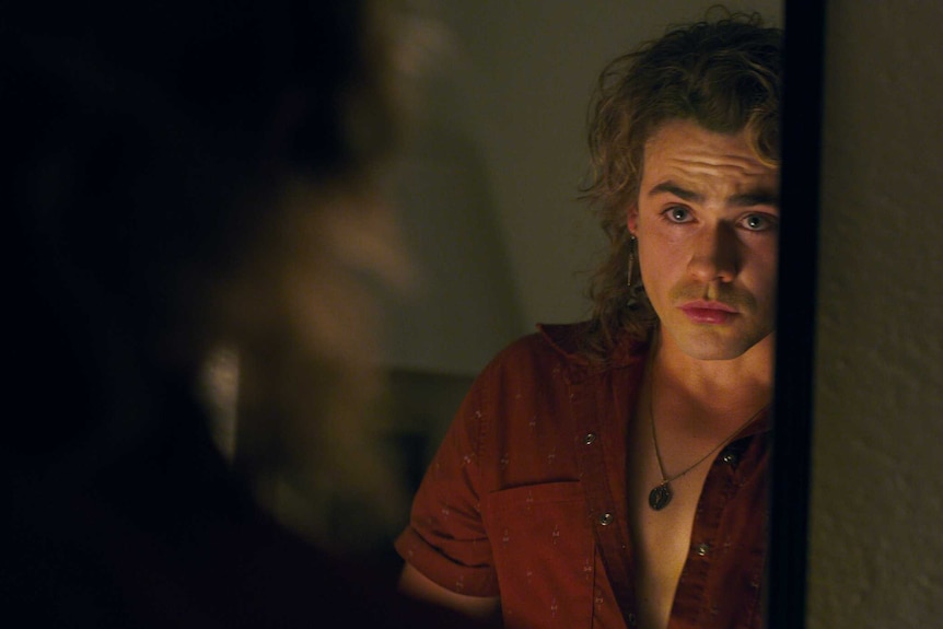 Dacre Montgomery looking in the mirror