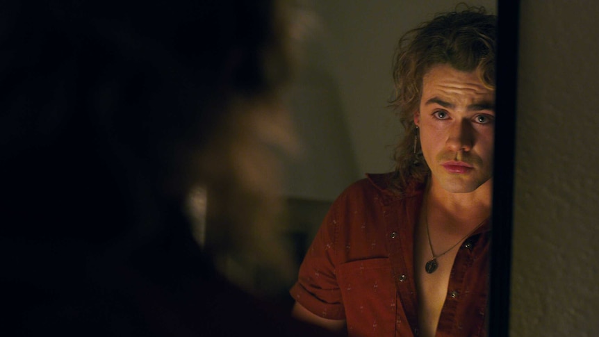 Dacre Montgomery looking in the mirror