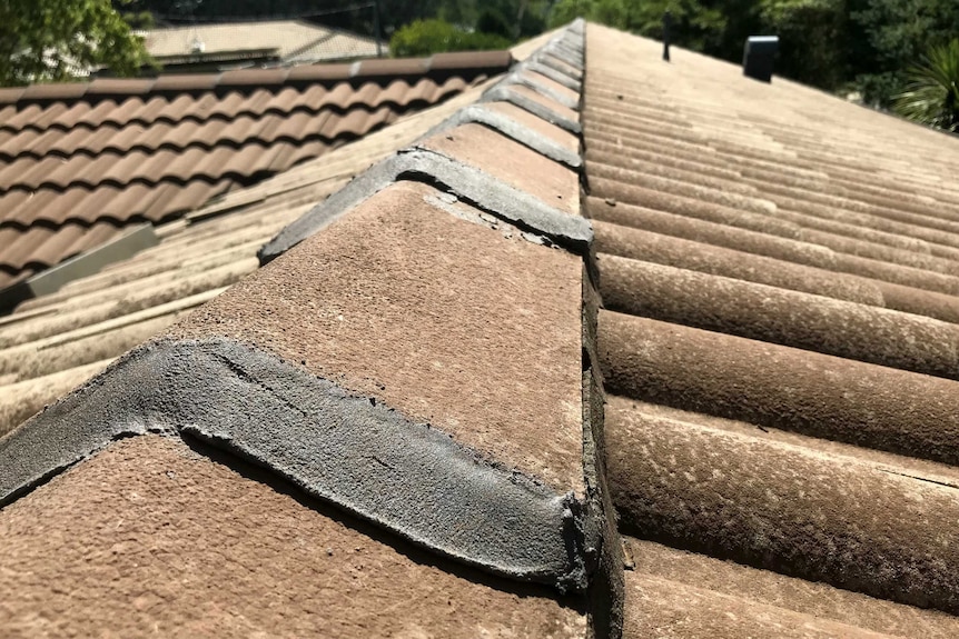 A roof with poorly sealed and concreted tiles.