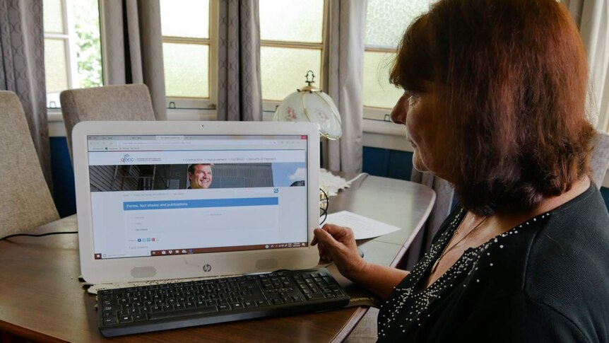 A woman sits in front of a computer