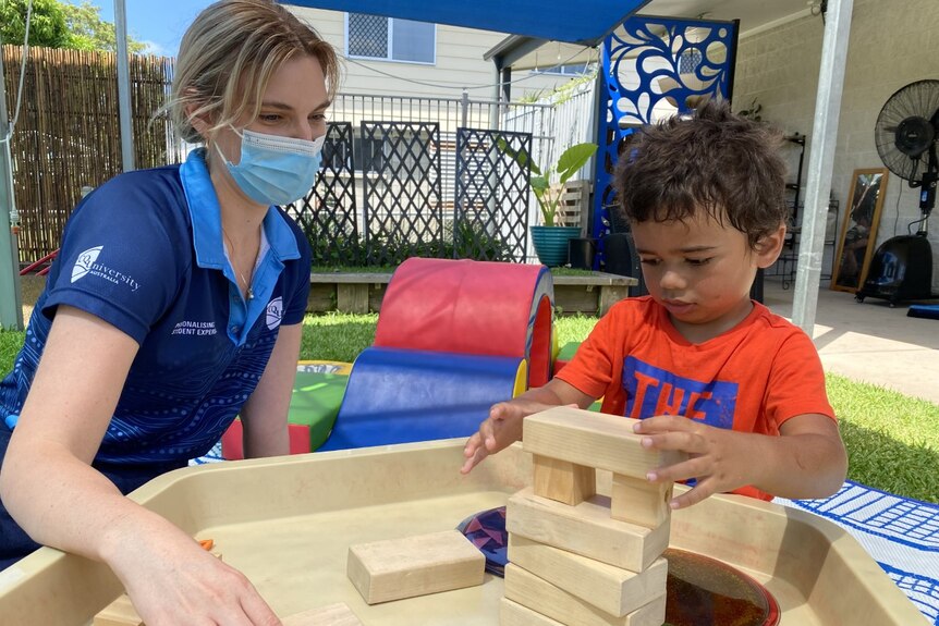 A woman and a toddler together with blocks to play with 