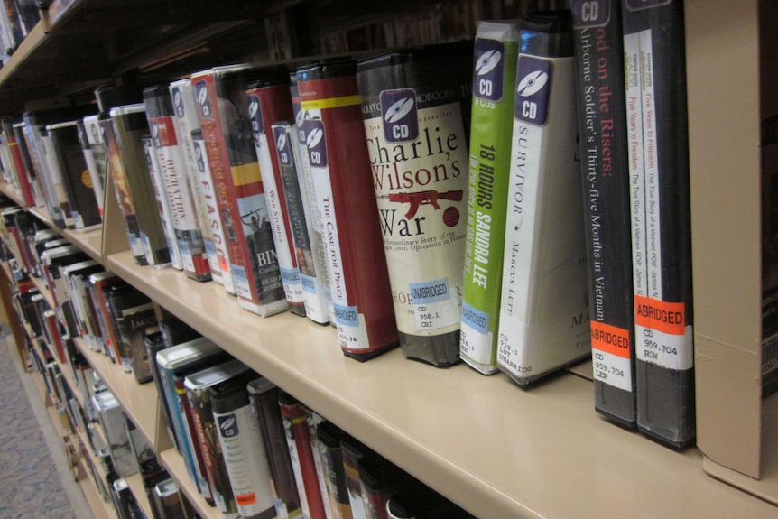 Audiobook CDs on a shelf at the library.