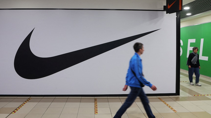 People walk past a closed store of the sporting goods retailer Nike at a shopping mall