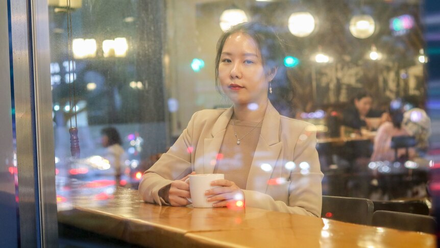 A woman photographed behind a glass window